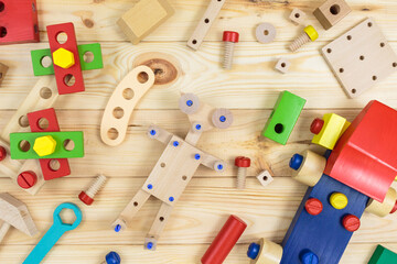 A colorful wooden building kit, wooden robot for children on wood. Set of tools on wooden table. Games and tools for kids in preschool or daycare. Natural, eco-friendly toys.