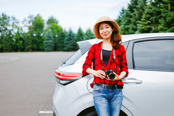 車とカメラを持つ女性