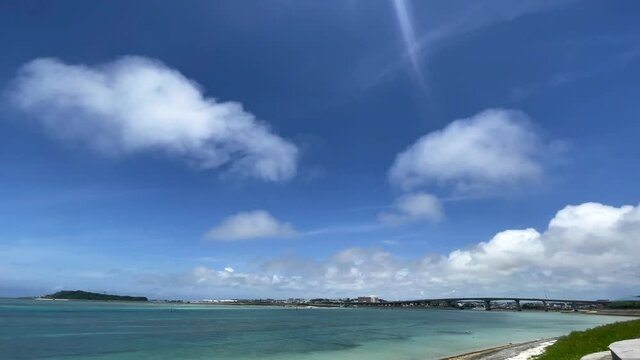 OKINAWA, JAPAN - JUNE 2021 : View of Senaga island and beach (Ocean or sea). Clear blue summer sky and clouds. Wide view time lapse shot in daytime.