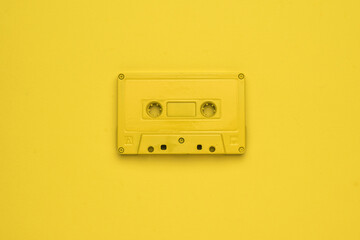 Monochrome image of a yellow tape recorder on a yellow background. Flat lay.