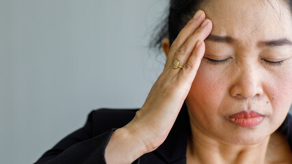 Fototapeta premium Middle age senior Asian woman feeling pain and suffer from sudden headache and brain stroke attack and hold her head with stressed face. Concept of brain and head problem