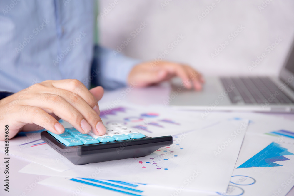 Aufkleber hands of businessman calculate tax with calculator while laptop computer on desk, man planning finan