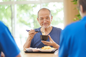 介護施設で楽しく食事をする高齢者