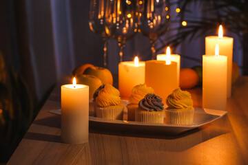 Table with candles and food in dark room
