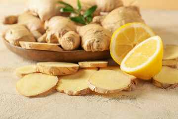 Fresh ginger slices and lemon on table