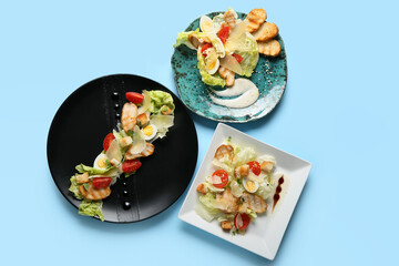 Plates with Caesar salad on color background