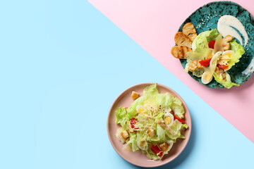 Plates with delicious Caesar salad on color background
