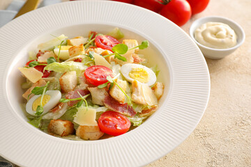 Plate with tasty Caesar salad and sauce on color background, closeup