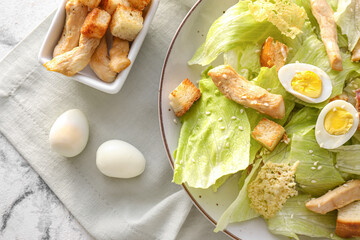 Plate with tasty Caesar salad on light background, closeup
