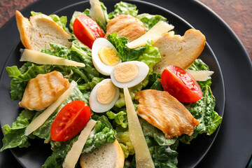 Plate with tasty Caesar salad on table, closeup