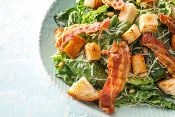 Plate with tasty Caesar salad on light background, closeup