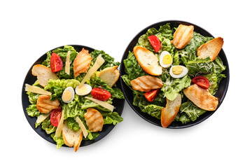 Plates with tasty Caesar salad on white background