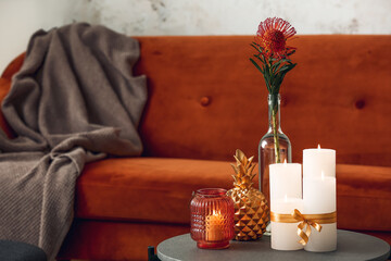 Burning candles with vase and decor in living room