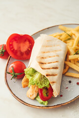 Plate with tasty doner kebab and french fries on light background, closeup