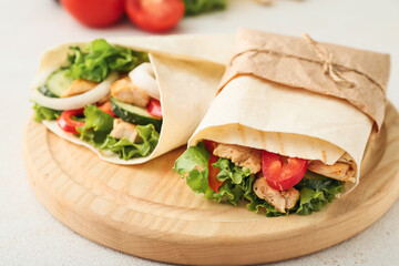 Board with tasty doner kebabs on light background, closeup