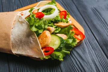 Board with tasty doner kebab on dark wooden background, closeup