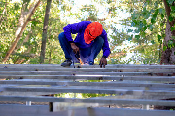 Welding the roof truss.welders working at dangerous heights. Welding of steel is very technically demanding and is only professional.