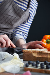 Woman making healthy sandwiches on the wooden board
