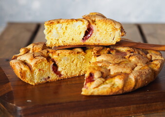 Apple summer seasonal charlotte pie with fresh apples and plums on a wooden kitchen board.Homemade cakes for tea.