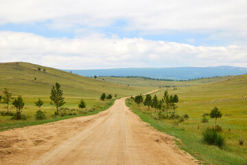 Fototapeta na wymiar A beautiful empty road among the steppe and mountains.