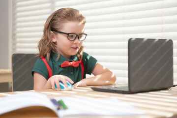 Smart school pupil kid virtual distance learning online, watching remote digital class lesson, looking at laptop computer studying at home.