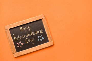 Chalkboard with text HAPPY INDEPENDENCE DAY on color background