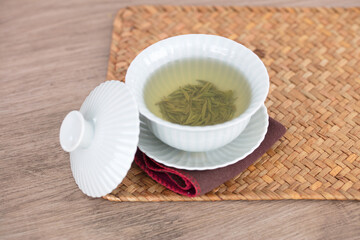 A bowl of green tea in a tureen on the mat