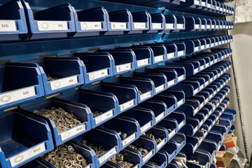 Shelf with spare screws in blue plastic boxes.