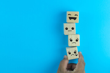 Customer pressing smiley face emoticon on wood cube, Service rating, satisfaction concept.