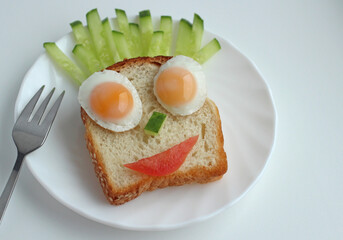 children's breakfast piece of bread with fried egg and fresh vegetables