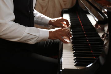 Fototapeta na wymiar Man playing piano indoors, closeup. Talented musician