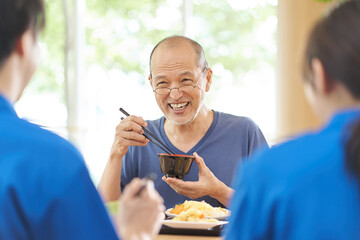 介護施設で楽しく食事をする高齢者