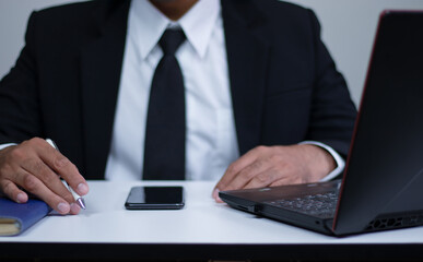 Businessman in suit with his work equipment and desk.