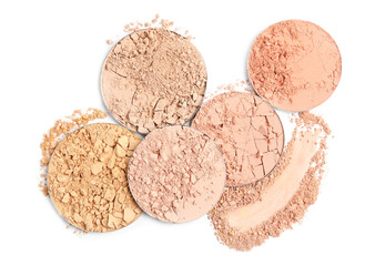 Different face powders and swatch on white background, top view