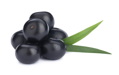 Pile of fresh ripe acai berries and green leaves on white background