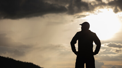 Silhouette Man standing on top of the mountain freedom life concept.