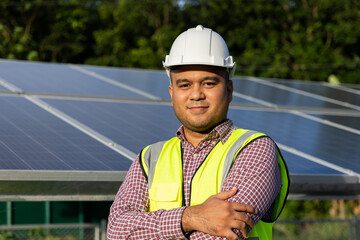 Young asian electrical engineer standing in front of Solar cell panels farm. He checking and installing. Solar generator power concept.
