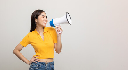 Shout out loud with megaphone. Young beautiful asian woman woman announces with a voice about...