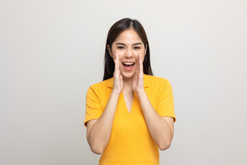 Excited asian woman shout out loud wow with hands on isolated background. Happy shocked face female...