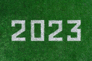 Date 2023 drawn in white paint on green grass