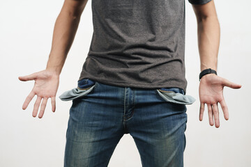 Man turning out the jean pocket to showing empty pocket. bankrupt, bad economy, no money concept.