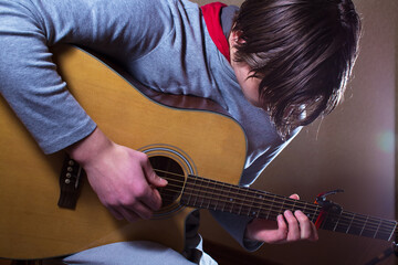 Fototapeta premium A young man plays the guitar.