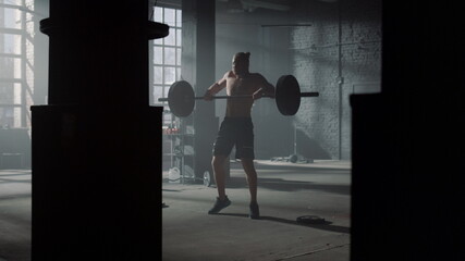 Fototapeta na wymiar Powerlifter doing weightlifting exercise in gym. Man performing front squat 