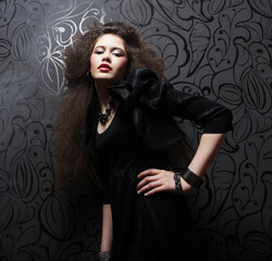 Beautiful young brunette woman with curly hair and bright make-up.