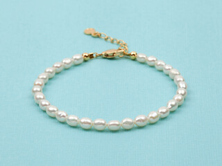 Luxury elegant baroque pearl bracelet on bright turquoise textured background