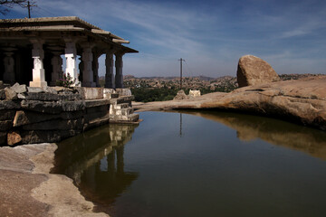 Fototapeta premium Temple on a pond overlooking the valley from Hemakuta Hill in Hampi, India