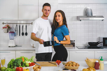 caucasian couple preparing salad for dinner together in kitchen