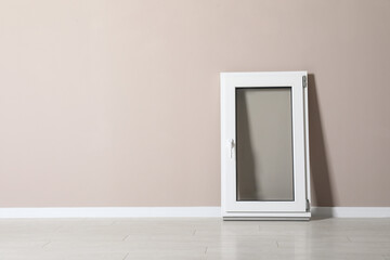 Modern single casement window near beige wall indoors, space for text