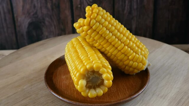 piece of sweet corn and seeds on wooden background, closeup