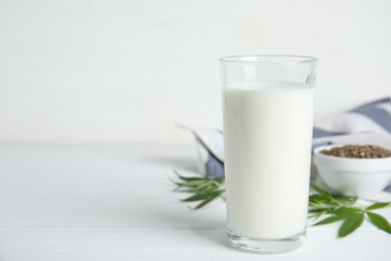 Obraz na płótnie Canvas Glass of fresh hemp milk on white wooden table. Space for text